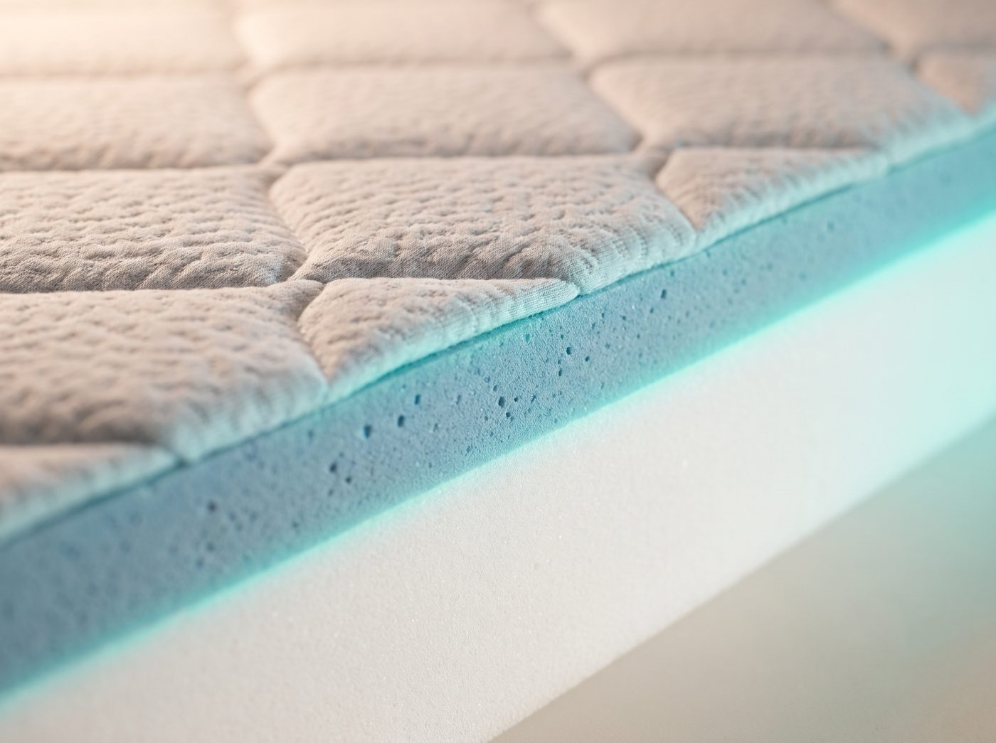 Corte transversal de um colchão técnico mostrando o tecido 3D, a espuma viscoelástica termossensível e o núcleo de suporte ortopédico